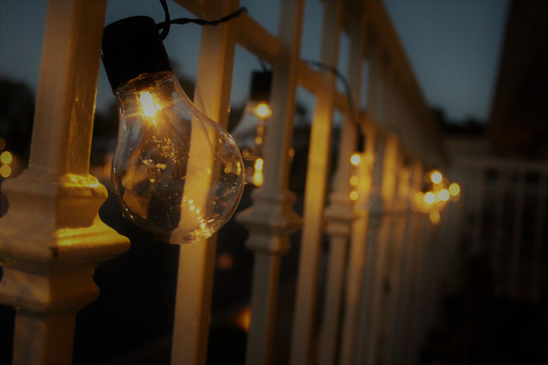 Warm glow from string lights during evening twilight, creating a cozy outdoor atmosphere.